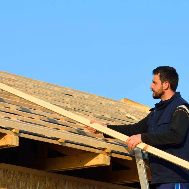 Couvreur intervenant sur la charpente dune maison